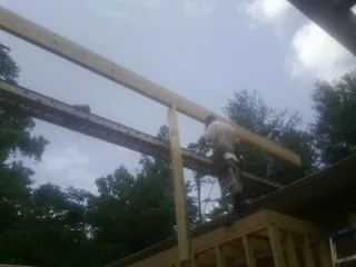 Carpenter setting a ridge beam over a new addition frame — Ice Dam Removal by Roofing Brothers in North Hampton