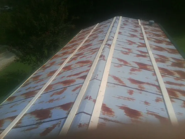 Rusted metal roof panels with new wood purlins before replacement — Storm Damage Roof Repair in North Hampton by Roofing Brothers