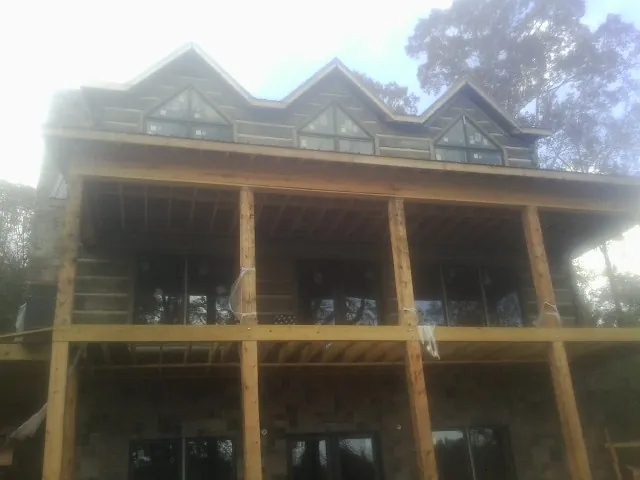 Dormers and porch framing on a large log home under construction — Roof Coating work by our crew in North Hampton