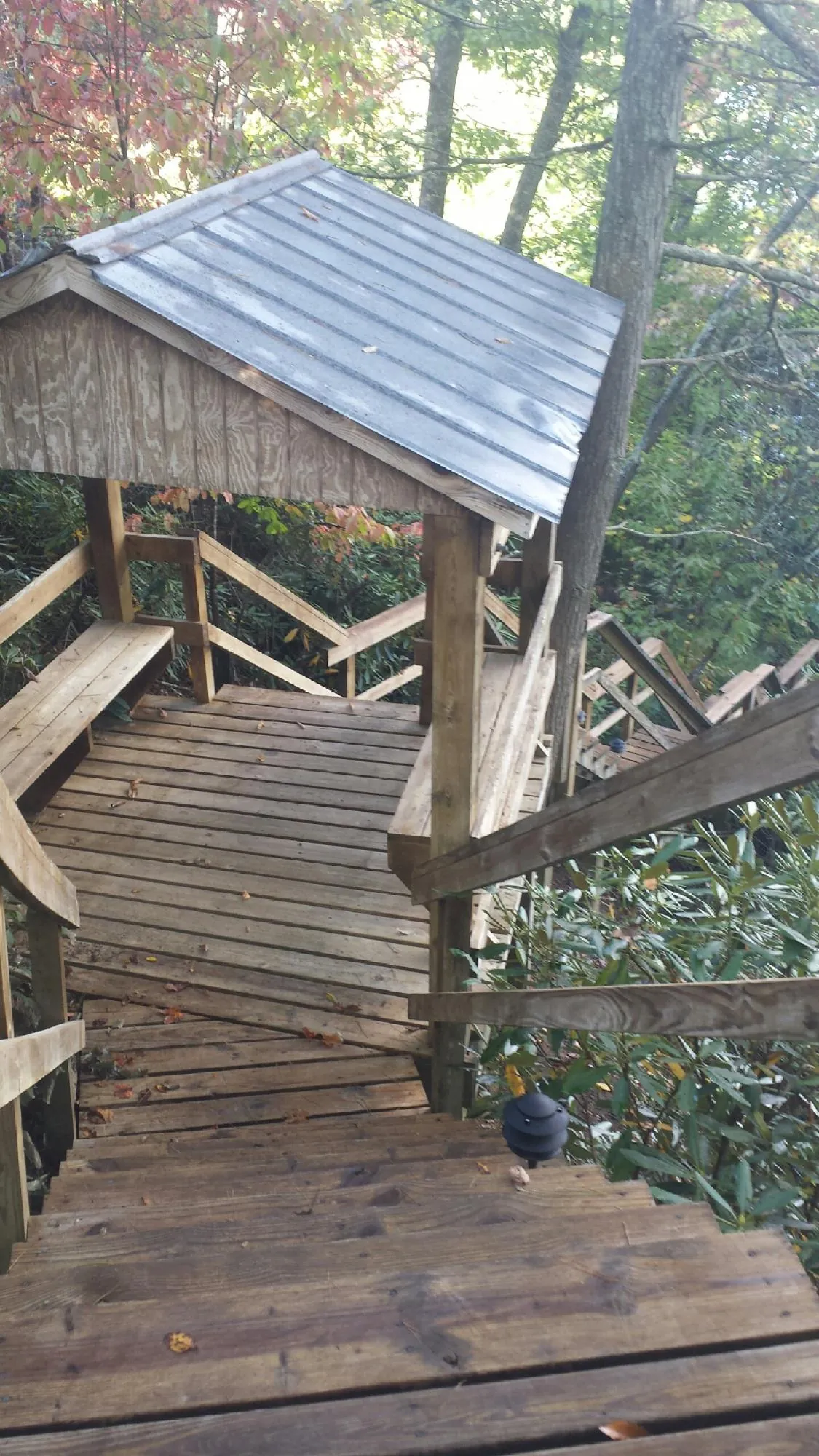 Metal roofed shelter over wooden steps on a wooded walkway — Skylight Repair & Installation work by our crew in North Hampton