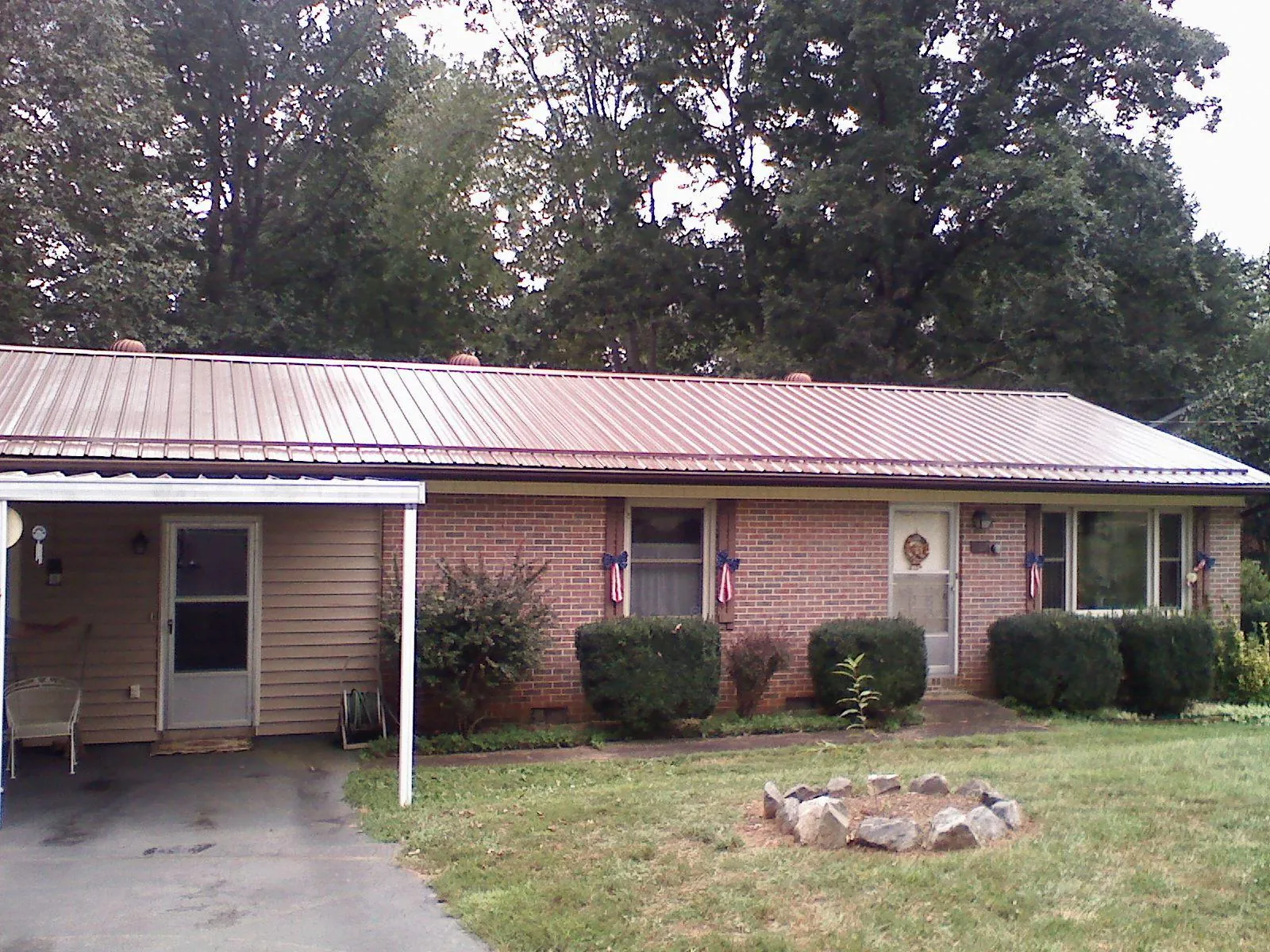 Bronze metal roof and carport on a brick ranch home — Roof Repair work by our crew in North Hampton